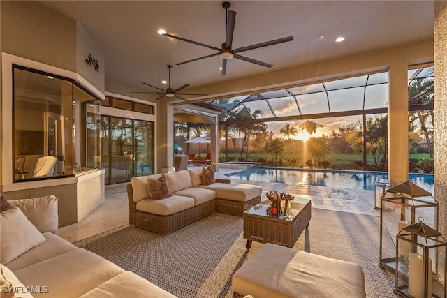 patio terrace at dusk featuring an outdoor hangout area, glass enclosure, and ceiling fan