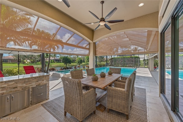 view of patio featuring an outdoor kitchen, ceiling fan, and a lanai