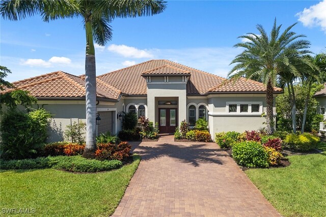 mediterranean / spanish house featuring a front yard and a garage