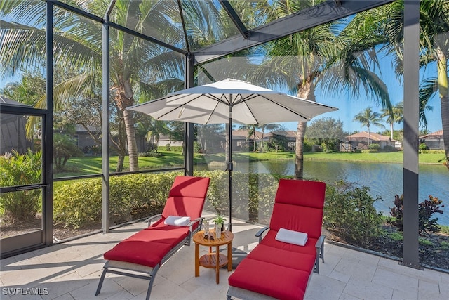 view of patio featuring a water view and a lanai