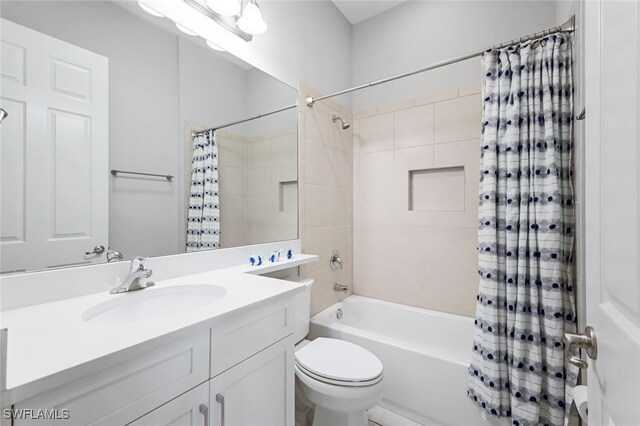 full bathroom with vanity, shower / bath combo with shower curtain, and toilet