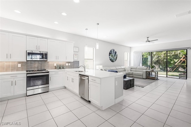 kitchen featuring ceiling fan, white cabinets, kitchen peninsula, pendant lighting, and appliances with stainless steel finishes