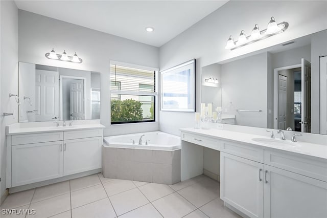 bathroom featuring vanity, tiled bath, and tile patterned flooring