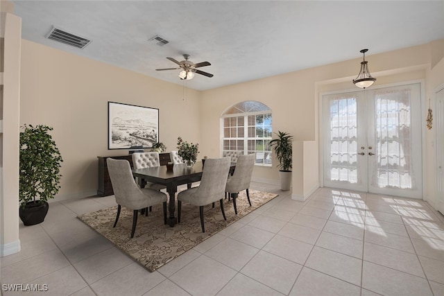 tiled dining area with ceiling fan and french doors