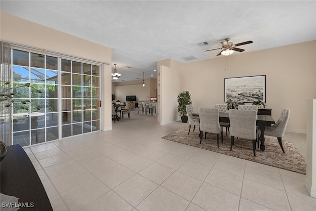 dining space featuring light tile patterned flooring and ceiling fan with notable chandelier