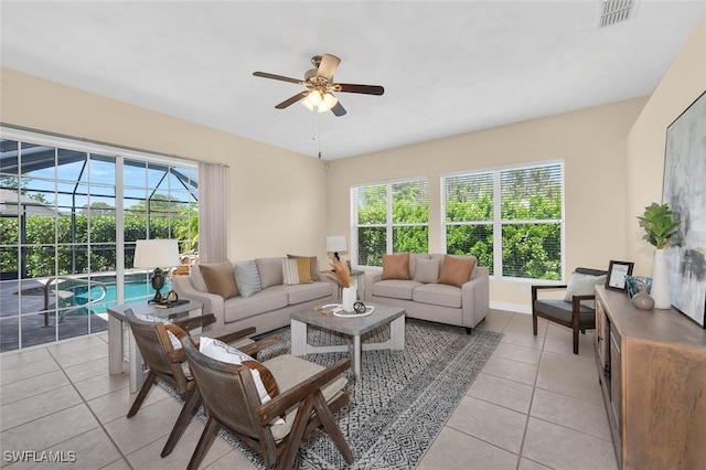 living room featuring light tile patterned floors, ceiling fan, and a healthy amount of sunlight