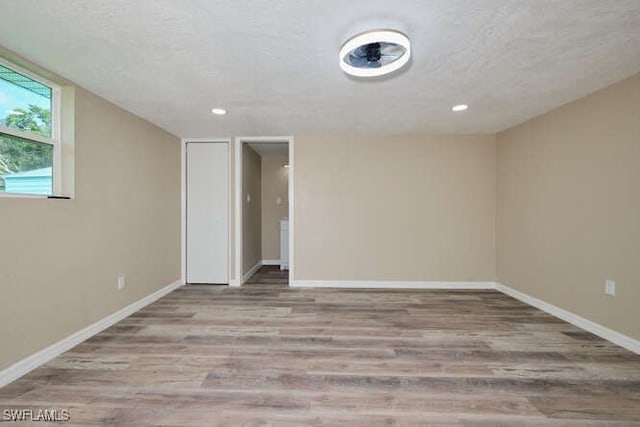 spare room featuring light hardwood / wood-style floors and a textured ceiling