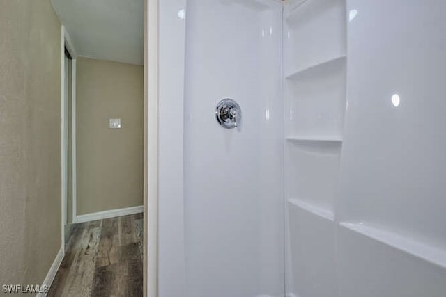 bathroom featuring hardwood / wood-style flooring and a shower