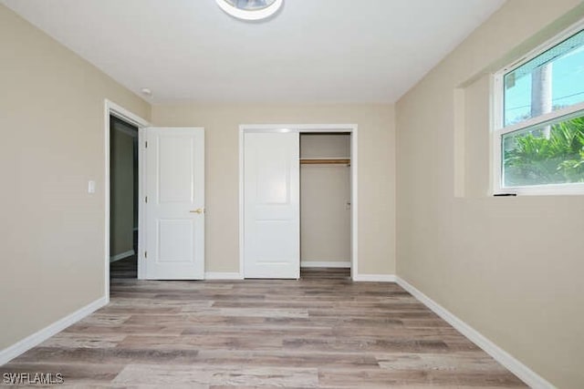 unfurnished bedroom featuring a closet and light wood-type flooring