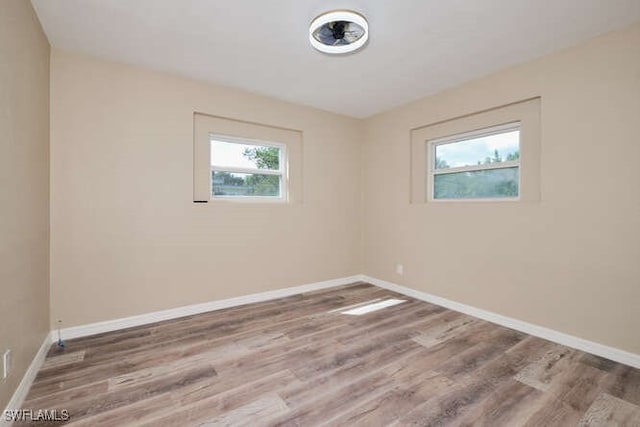 spare room with a wealth of natural light and hardwood / wood-style floors