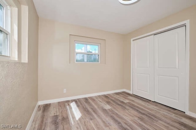 unfurnished bedroom featuring light hardwood / wood-style flooring and a closet