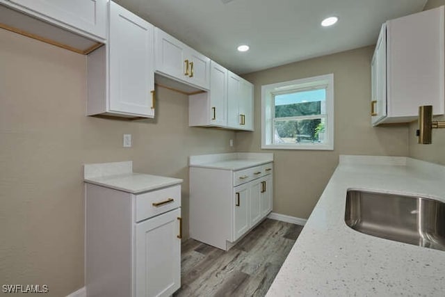 kitchen with white cabinetry and light hardwood / wood-style flooring