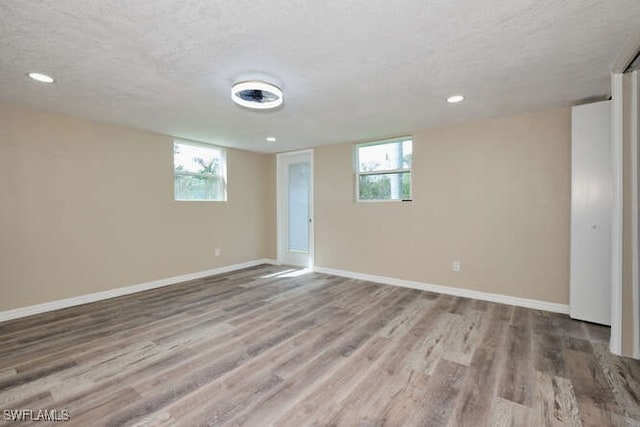 interior space featuring a healthy amount of sunlight, wood-type flooring, and a textured ceiling