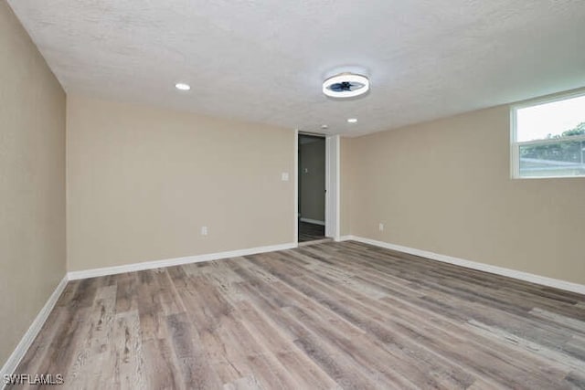 spare room with light hardwood / wood-style floors and a textured ceiling