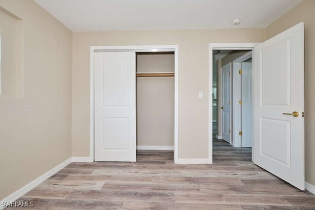 unfurnished bedroom featuring a closet and light hardwood / wood-style flooring