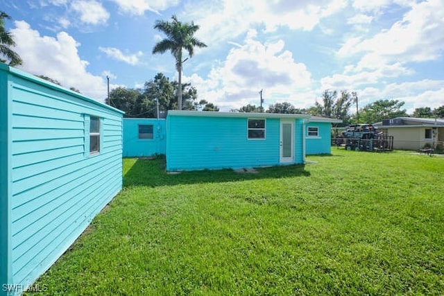 rear view of property featuring a lawn