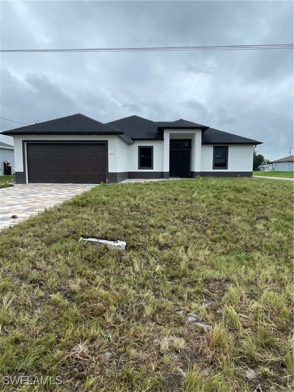 view of front of home with a front yard and a garage