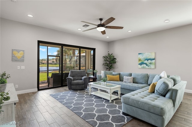 living room with recessed lighting, visible vents, baseboards, and wood finished floors