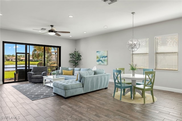 living room with ceiling fan with notable chandelier