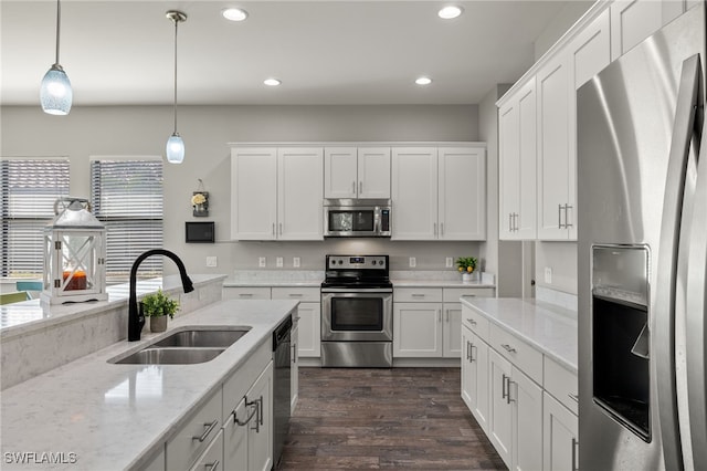 kitchen featuring white cabinets, dark wood-type flooring, stainless steel appliances, and a sink