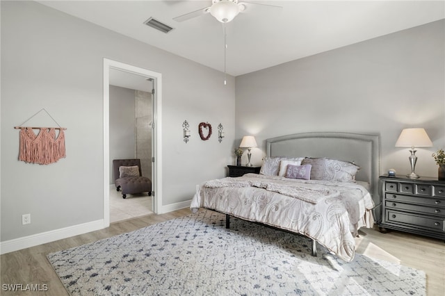 bedroom with a ceiling fan, wood finished floors, visible vents, and baseboards