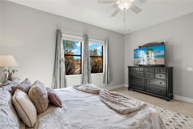 bedroom with a ceiling fan, light wood-type flooring, and baseboards