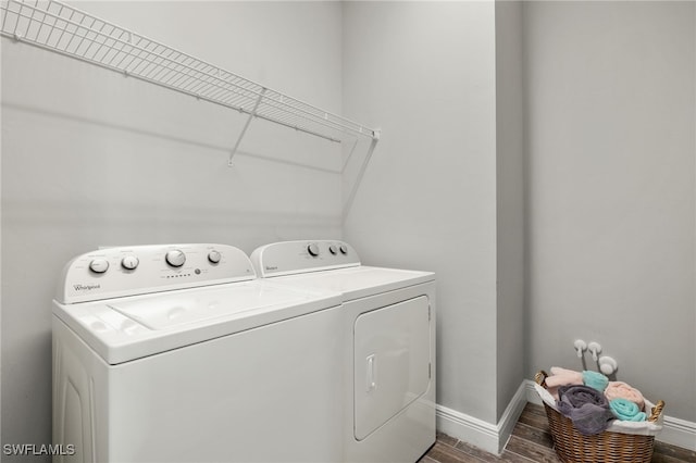 laundry area featuring dark wood-type flooring, laundry area, baseboards, and washing machine and clothes dryer