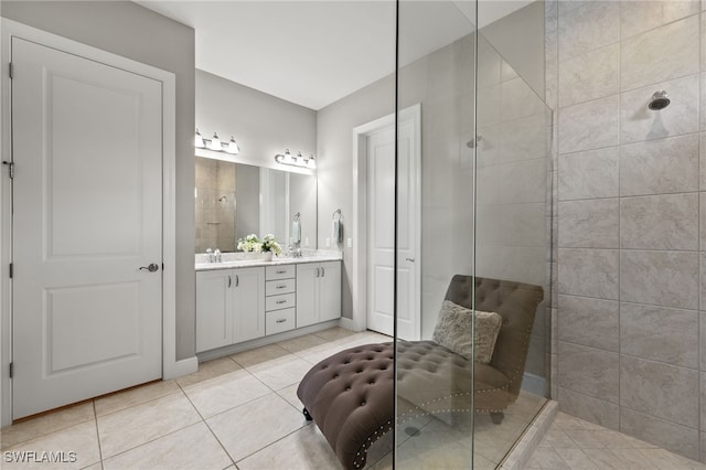 bathroom with double vanity, a shower stall, a sink, and tile patterned flooring