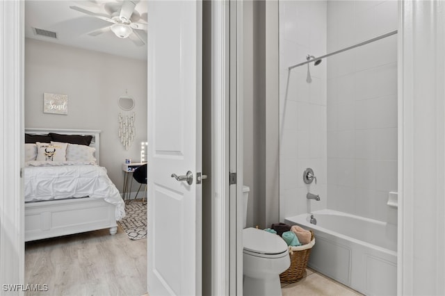 ensuite bathroom featuring visible vents, shower / bathing tub combination, toilet, connected bathroom, and wood finished floors