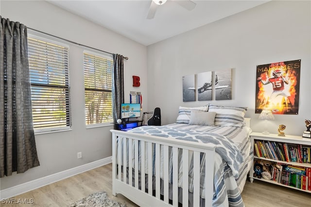 bedroom featuring a ceiling fan, baseboards, and wood finished floors