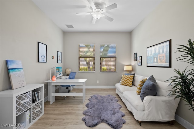 office with a ceiling fan, light wood-style flooring, visible vents, and baseboards