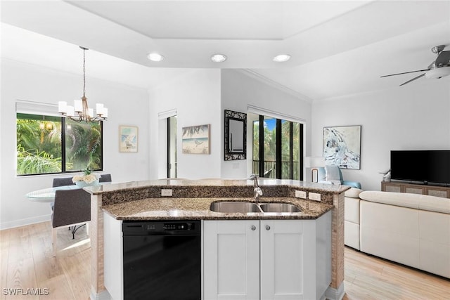 kitchen with decorative light fixtures, white cabinetry, dark stone countertops, and sink