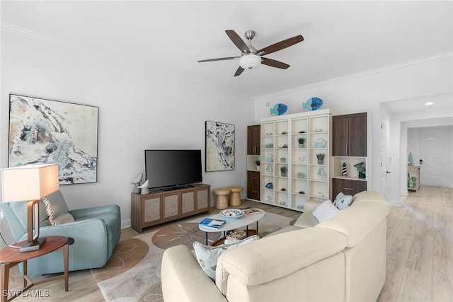 living room featuring ceiling fan, ornamental molding, and light wood-type flooring