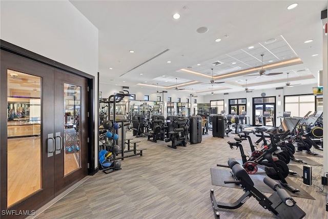 exercise room featuring ceiling fan, light carpet, and french doors