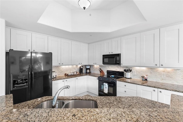 kitchen featuring sink, light stone counters, and black appliances