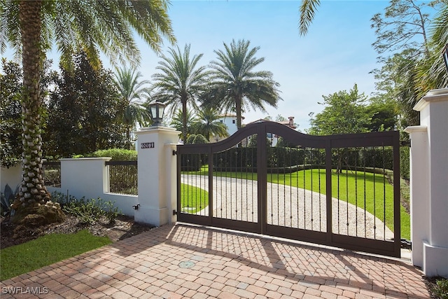 view of gate with a lawn