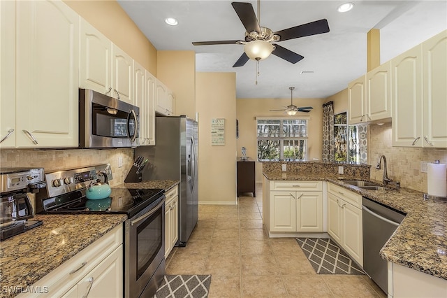 kitchen with kitchen peninsula, dark stone countertops, and stainless steel appliances