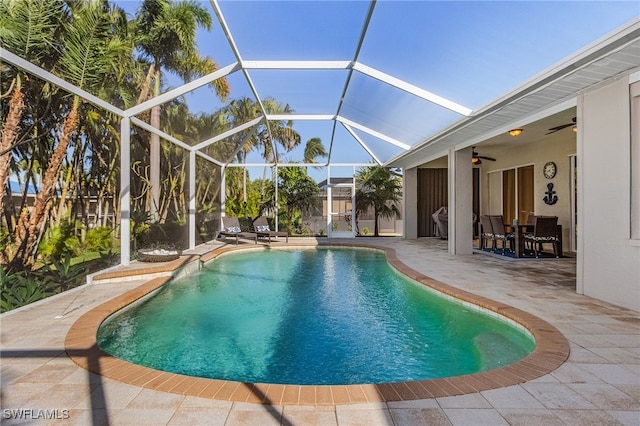 view of swimming pool featuring a lanai, ceiling fan, and a patio area