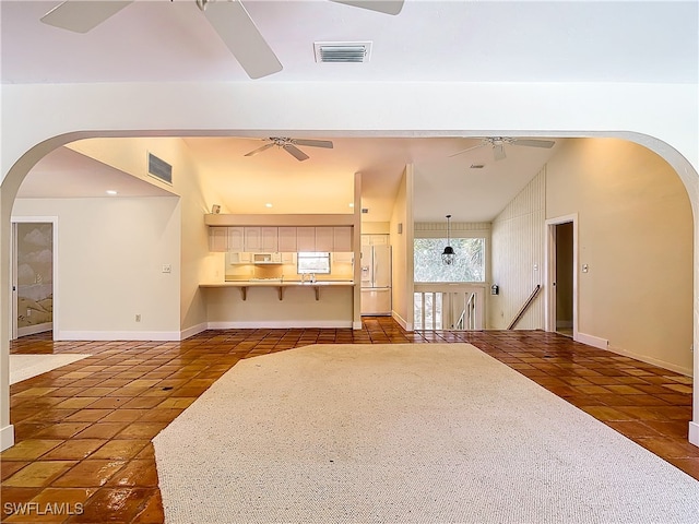 unfurnished living room with lofted ceiling and dark tile patterned floors