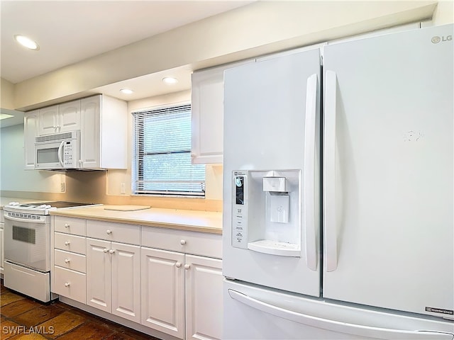 kitchen with white appliances, dark hardwood / wood-style floors, and white cabinets