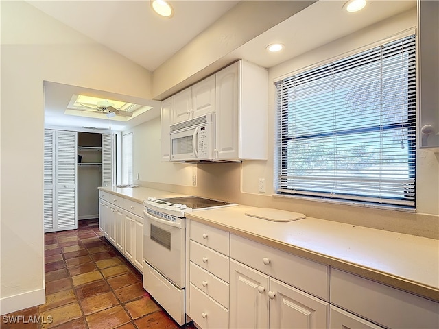 kitchen featuring ceiling fan, vaulted ceiling, white appliances, and white cabinetry