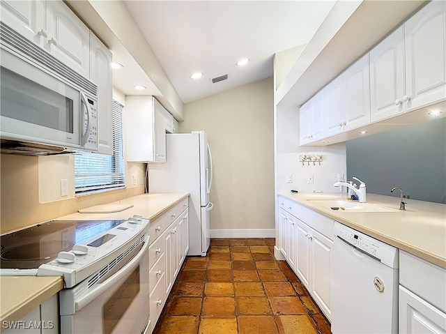 kitchen featuring white appliances, white cabinets, and sink