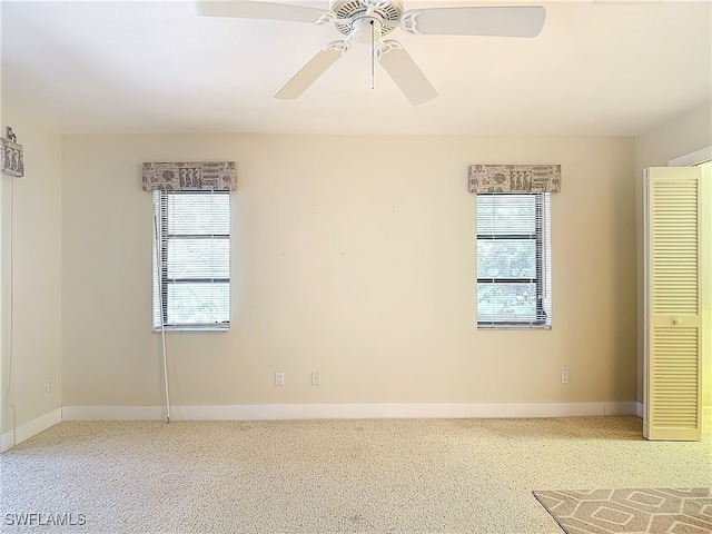 unfurnished bedroom featuring multiple windows, ceiling fan, and carpet