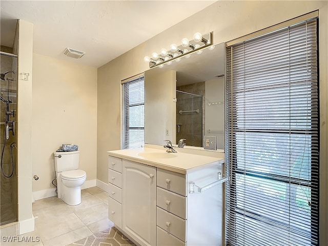 bathroom with a shower with door, tile patterned floors, vanity, and toilet