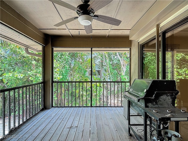 unfurnished sunroom featuring ceiling fan