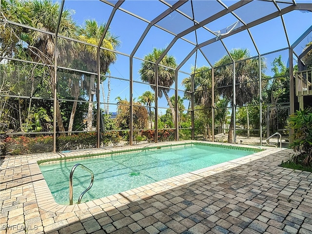 view of swimming pool featuring a patio and a lanai