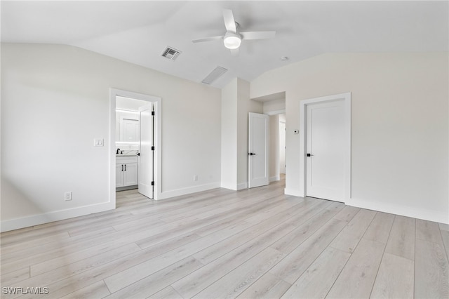 empty room with ceiling fan, light wood-type flooring, and vaulted ceiling