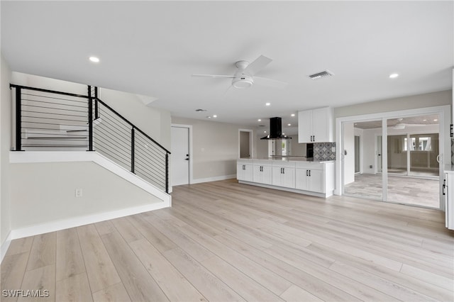 unfurnished living room featuring ceiling fan and light hardwood / wood-style floors