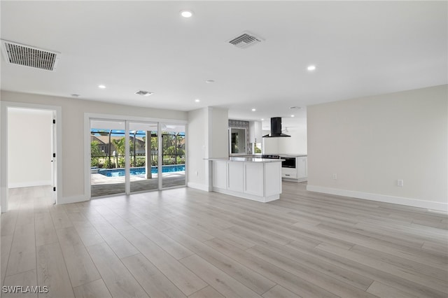 interior space with exhaust hood, light hardwood / wood-style floors, and white cabinets