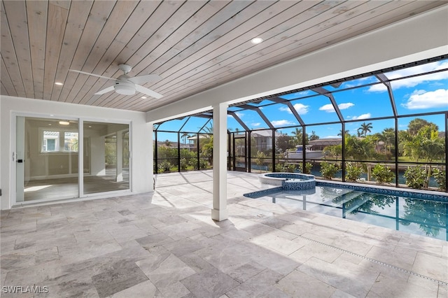 view of pool with ceiling fan, glass enclosure, an in ground hot tub, and a patio area